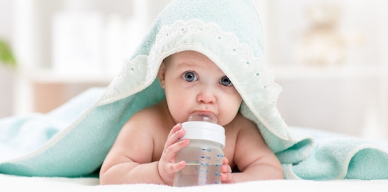 adorable child baby drinking water from bottle