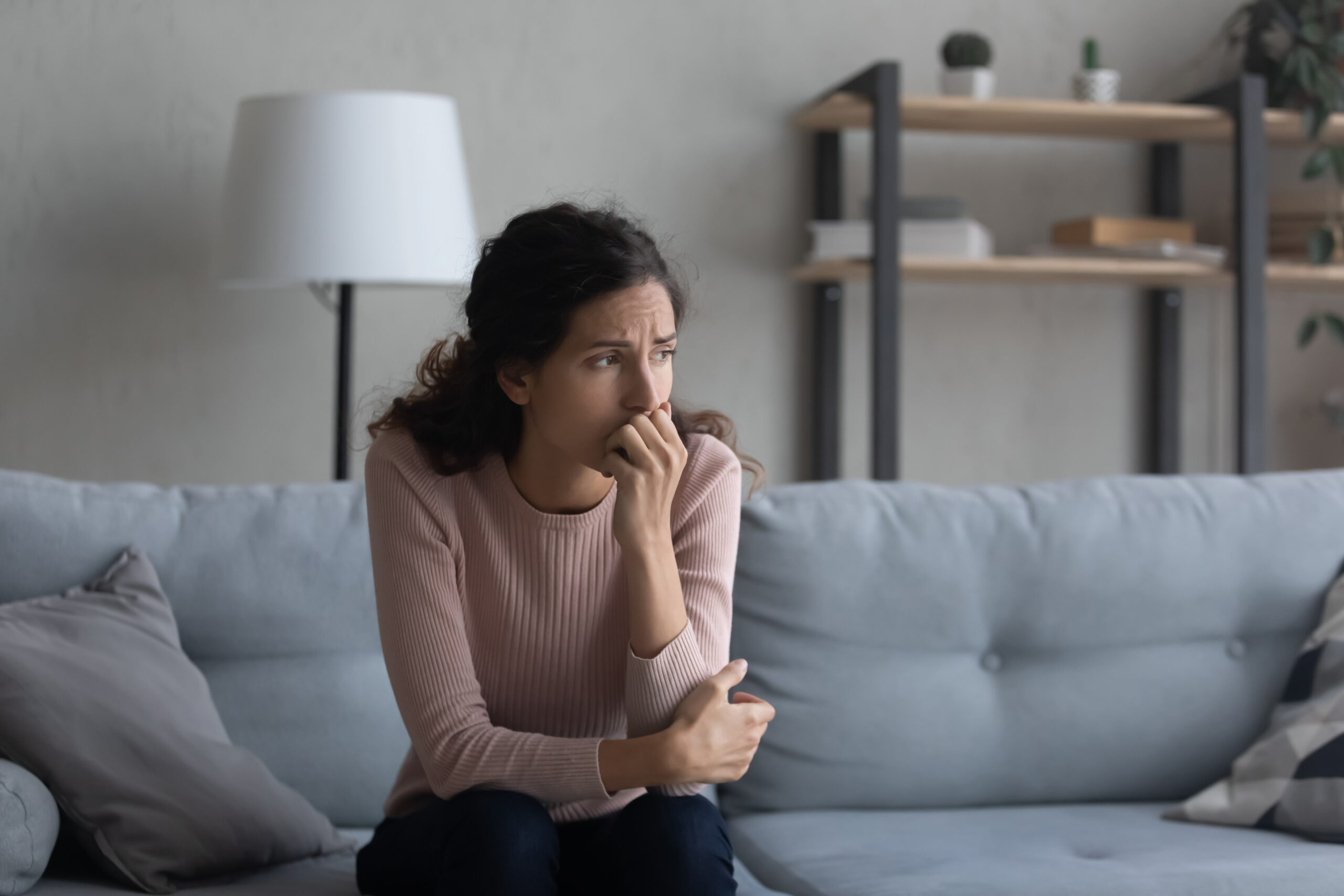 Sad,Young,Caucasian,Woman,Sit,On,Couch,At,Home,Look